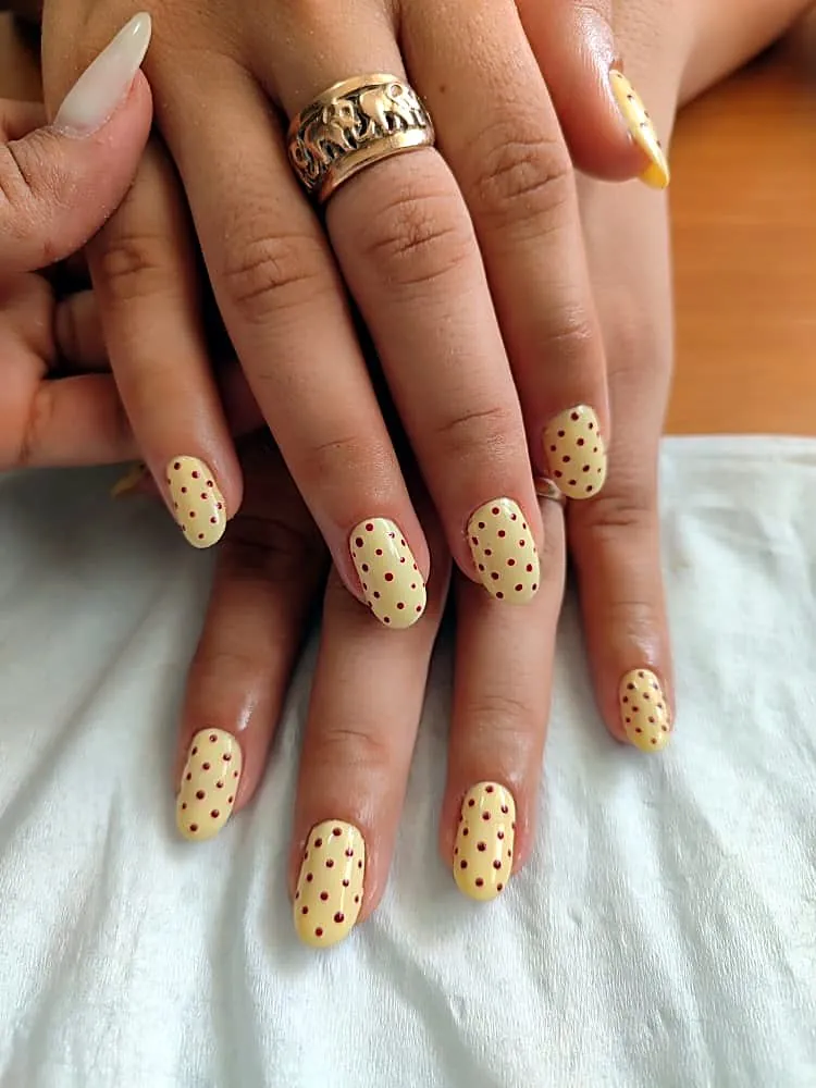 Uñas cortas amarillo mantequilla con lunares rojos