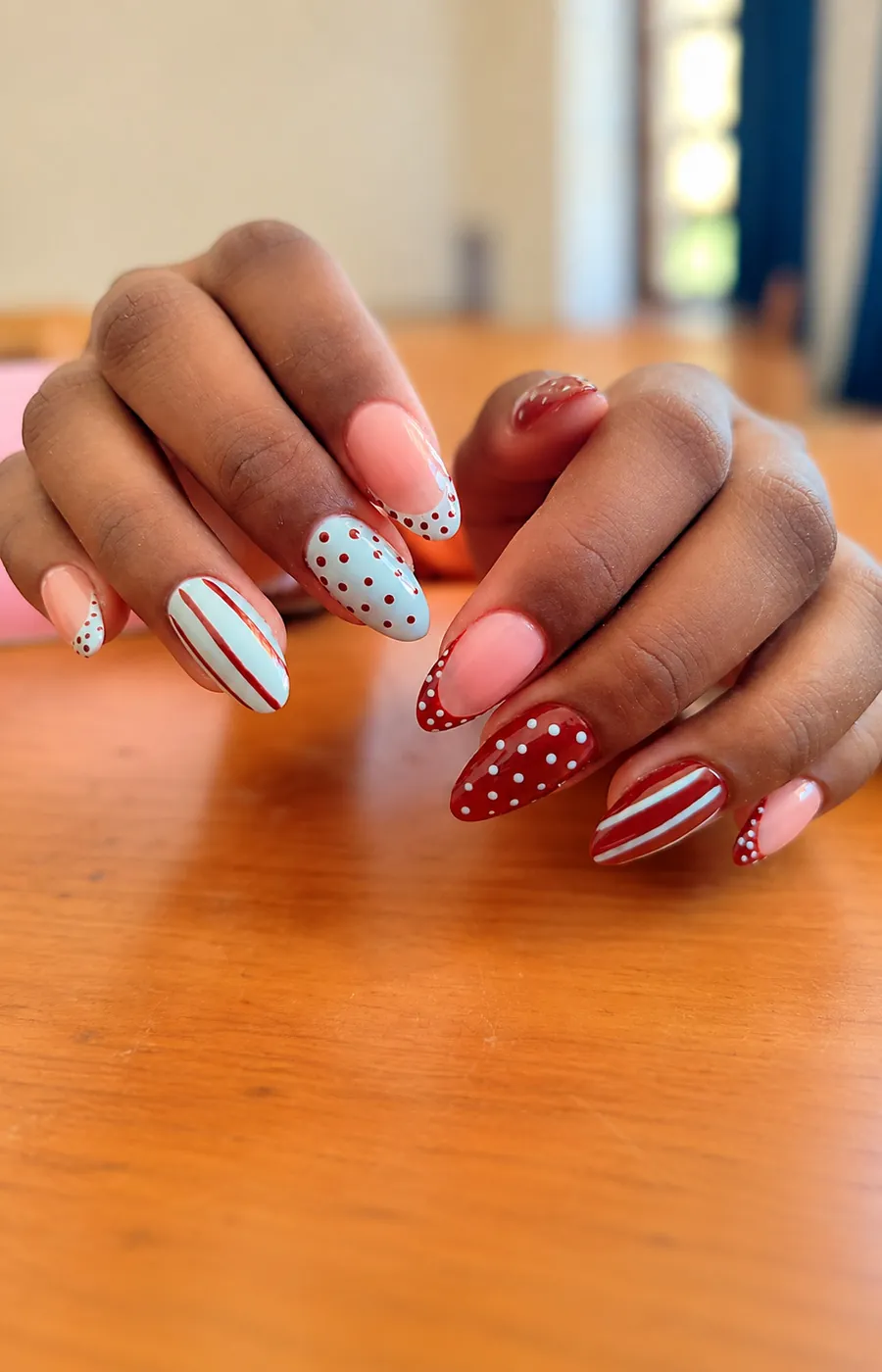Uñas almendradas terracota y azul claro con lunares rojos y blancos y rayas