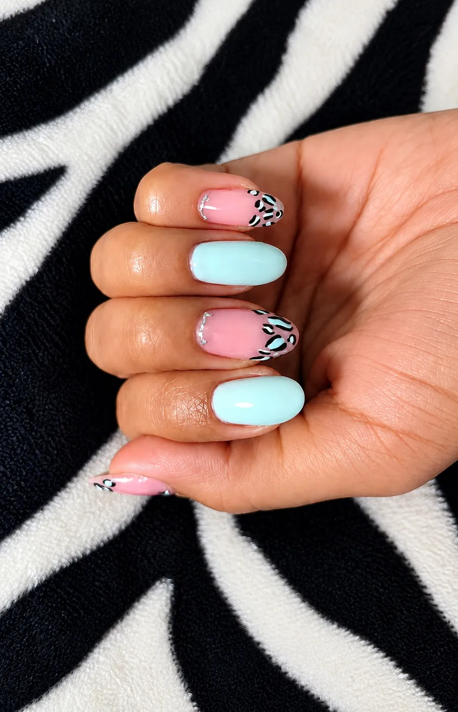 Uñas almendradas menta y rosa con estampado de leopardo blanco y negro